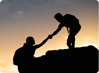 A person helping another one climb a hill