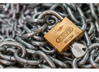 This image shows a lock and key on a chain pile