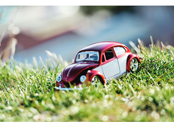 Toy dark red vintage car on grass
